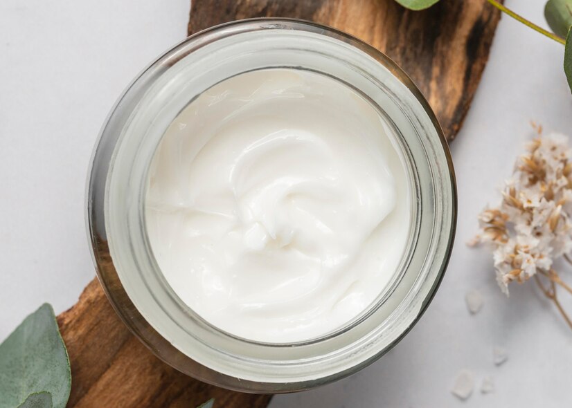 top-view-cream-container-flowers_23-2148899421